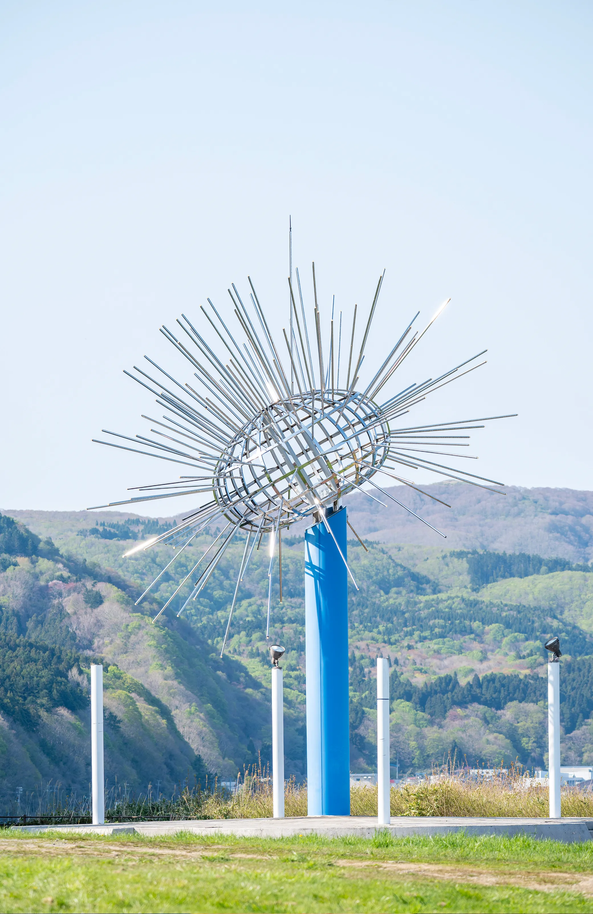 海に突き出た岩場の上に建つ赤い屋根の神社と青い海